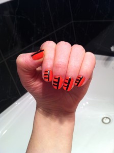 Orange manicure with black stripes