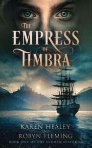 A three-masted sailing ship is nearing a mountainous bay. The sun is rising or setting over a mountain-top palace. Above the gold-lettered title "The Empress of Timbra"m we see a pale young face with blue eyes staring at the reader.